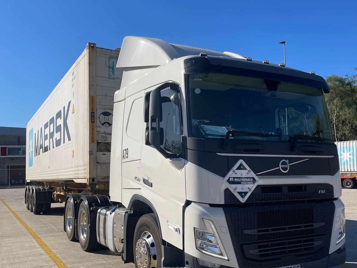 An Aardiv prime mover with a loaded container trailer at a customer site