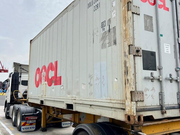 A loaded 40-foot OOCL container on a skeletal trailer, seen from the drive side