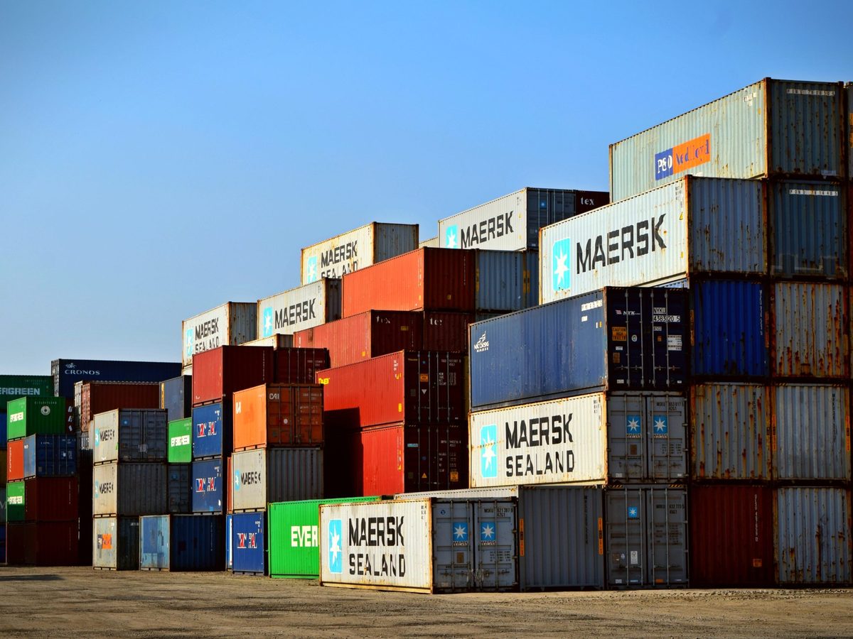 Shipping containers of several types and sizes stacked at a container depot