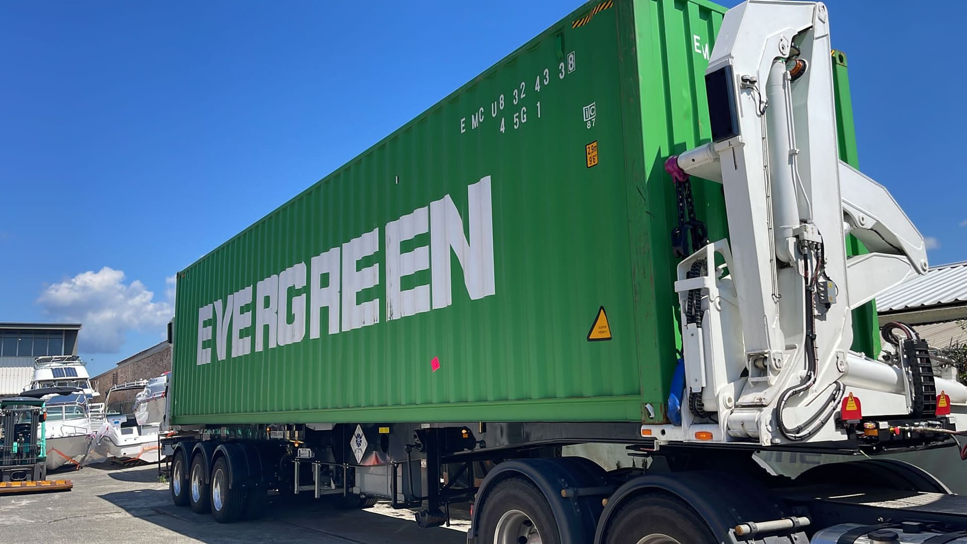 An Aardiv side loader carrying a 40-foot shipping container